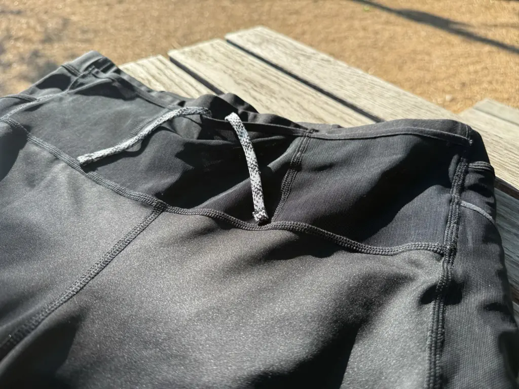 A close up, angled view of the front of the half tights, showing the mesh front pockets and drawstring