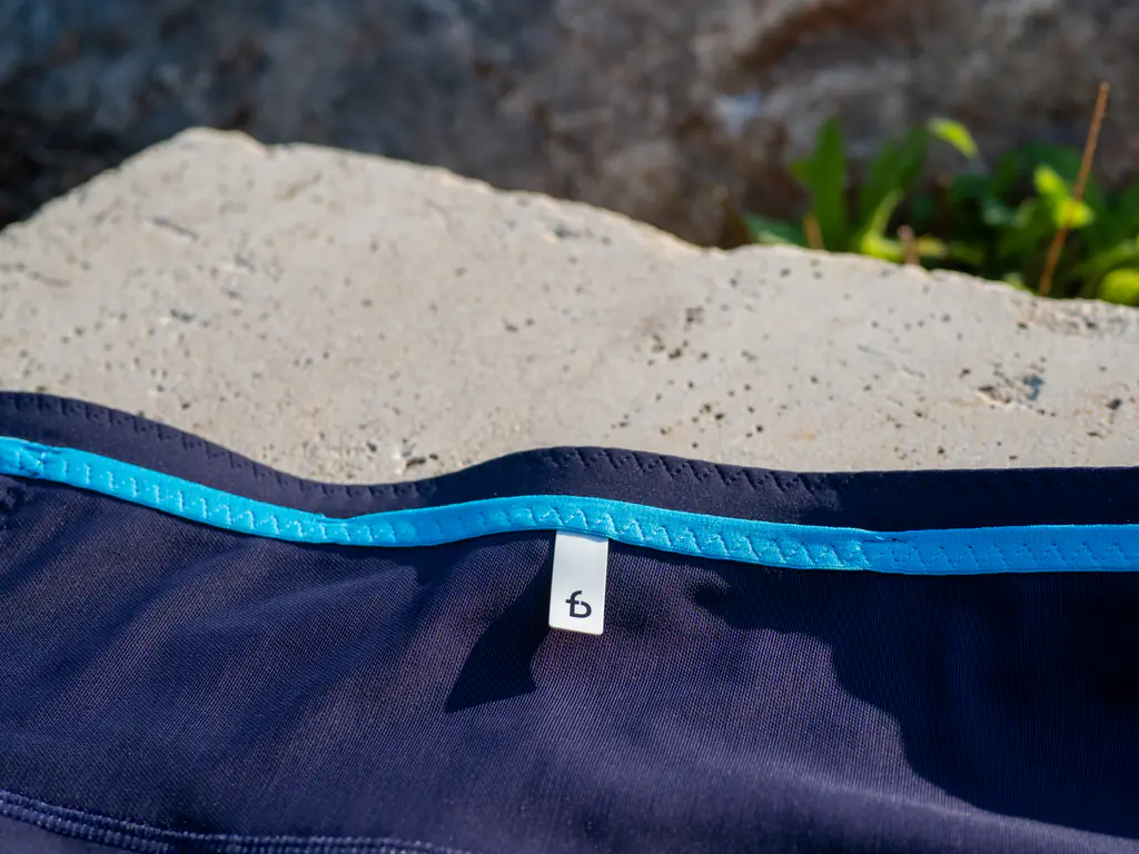 A closeup of the small pull tab on the front waist storage, making it easy to pull open