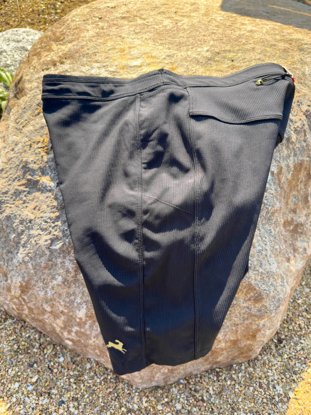 An overall side shot of the half tights, showing the drop-in leg pockets sitting high, up against the waistband.