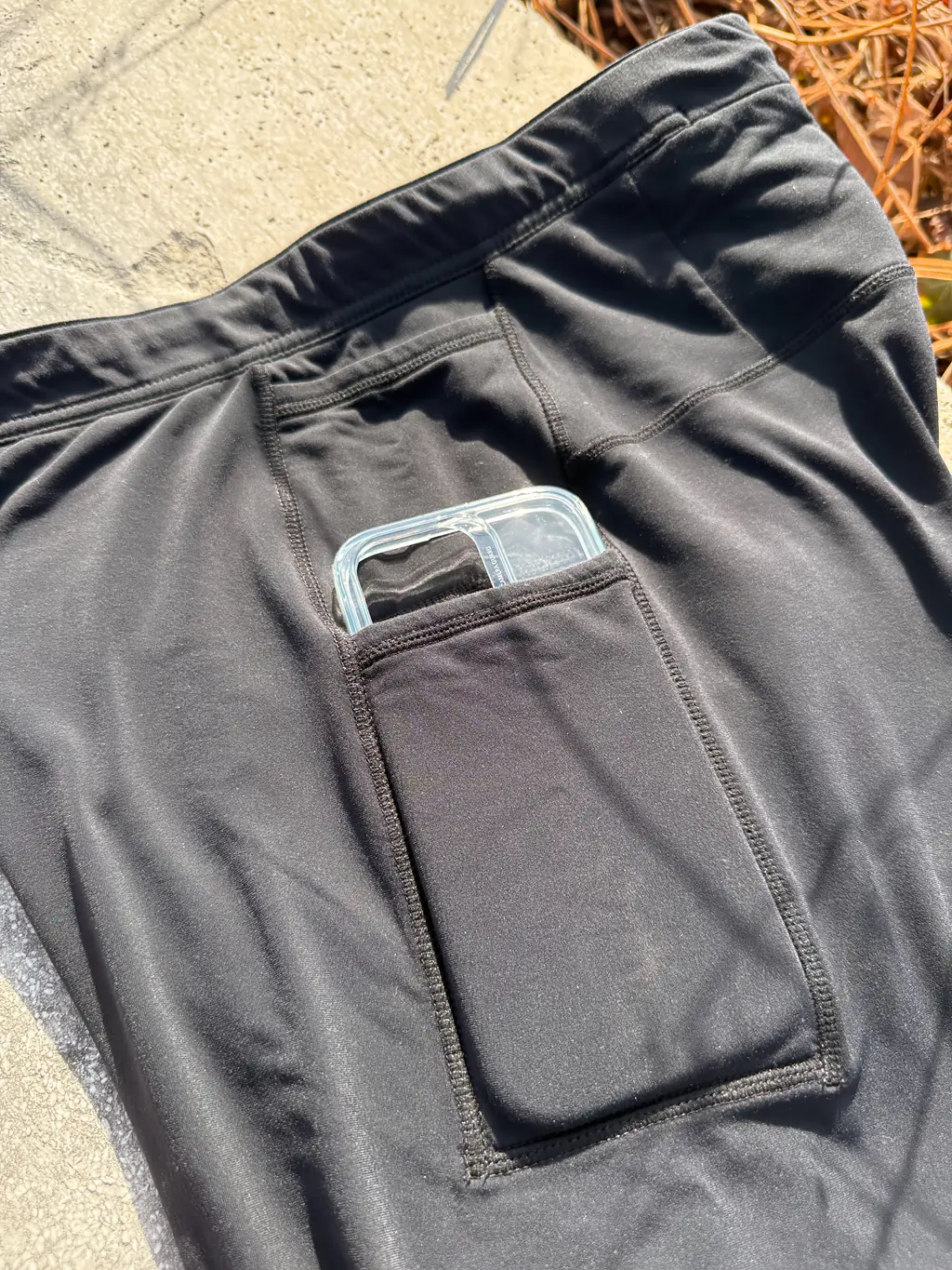 A closer shot of an iPhone 16 Pro case in the larger (bottom) pocket, showing the fit (a little bit of the camera segment and top of iPhone stick out of the top)