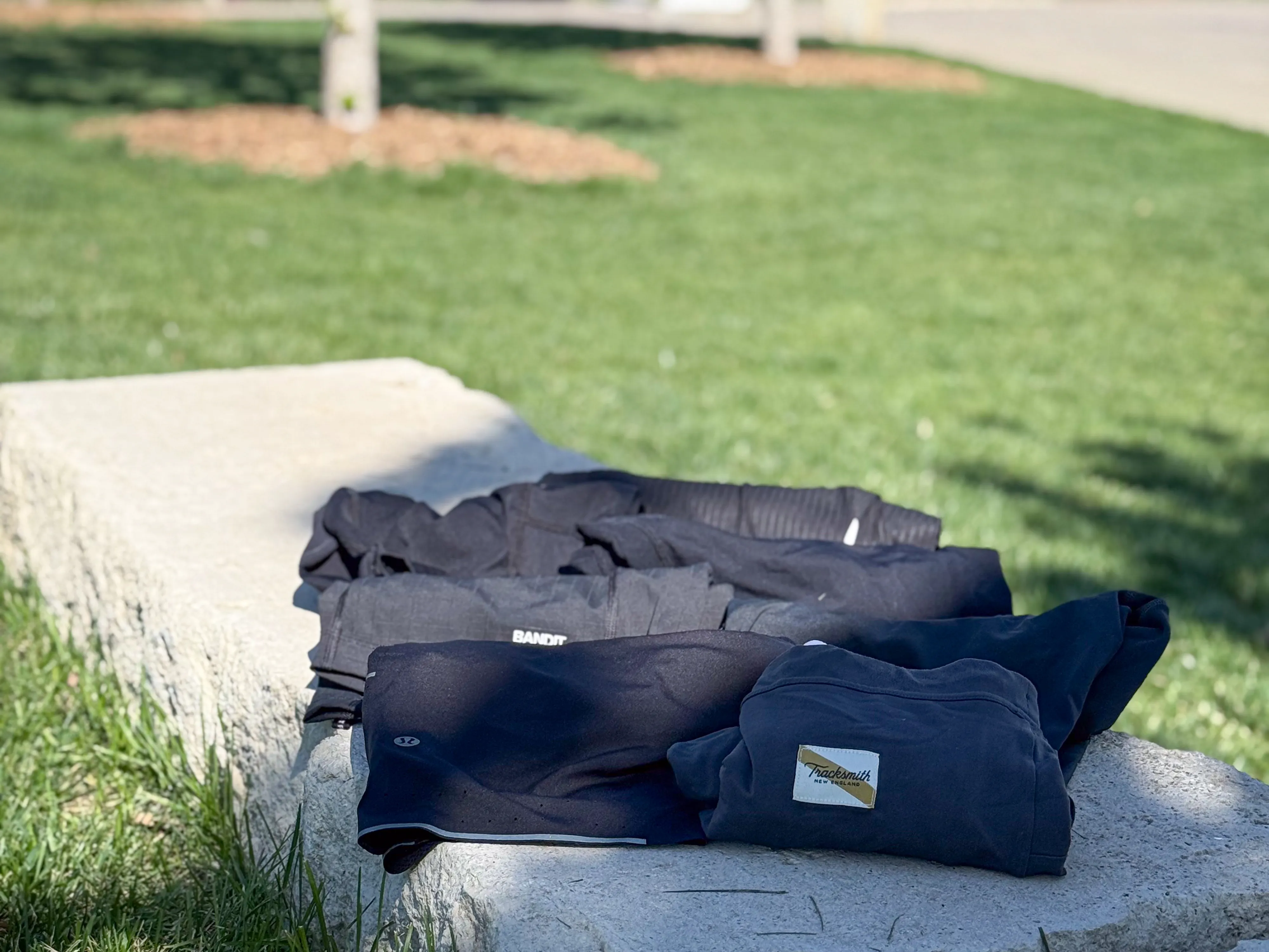 A variety of half tights sitting on a rock bench, all rolled up