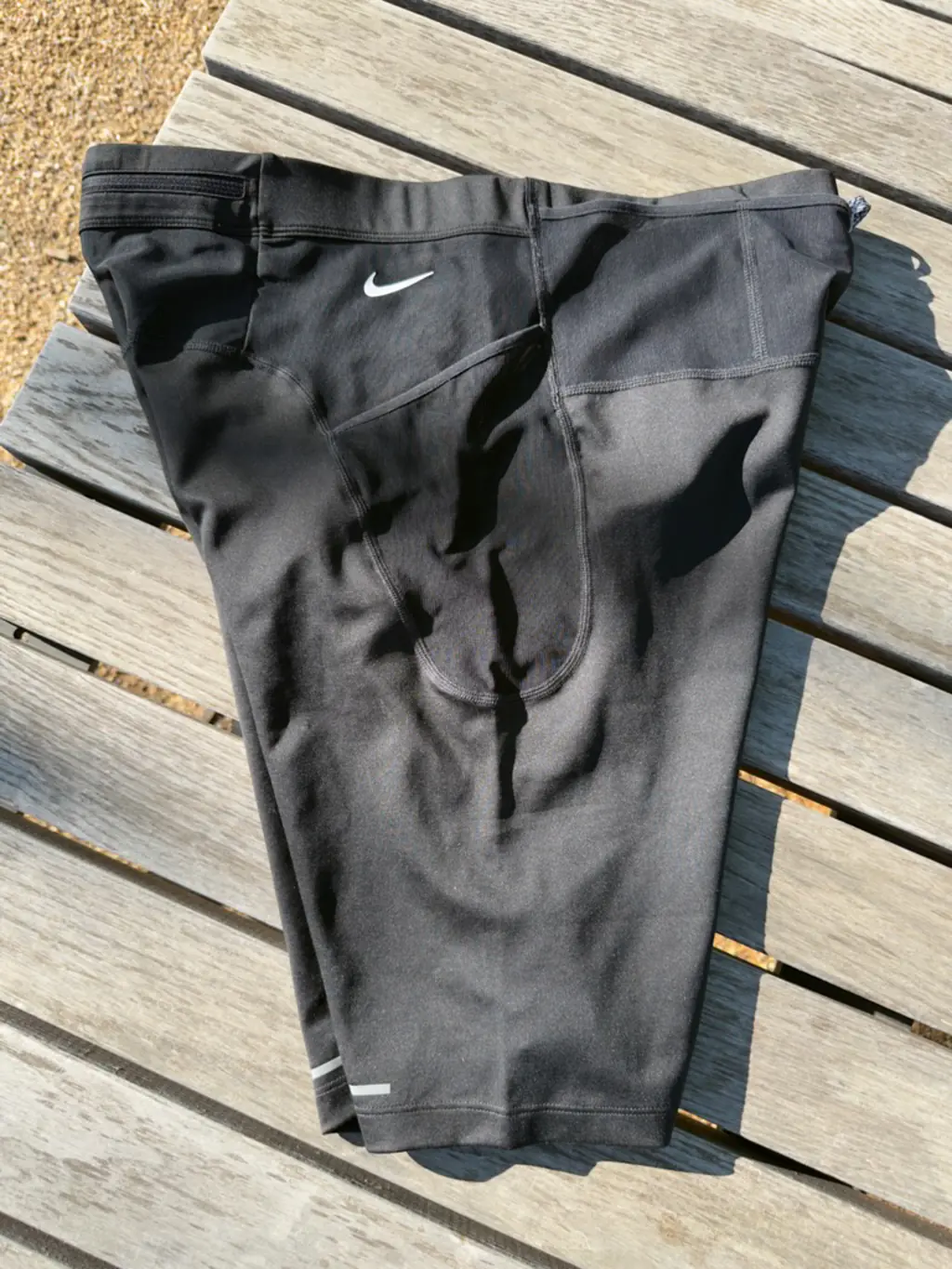 An overall side view of the half tights, showing the large, non-rectangular main side pocket