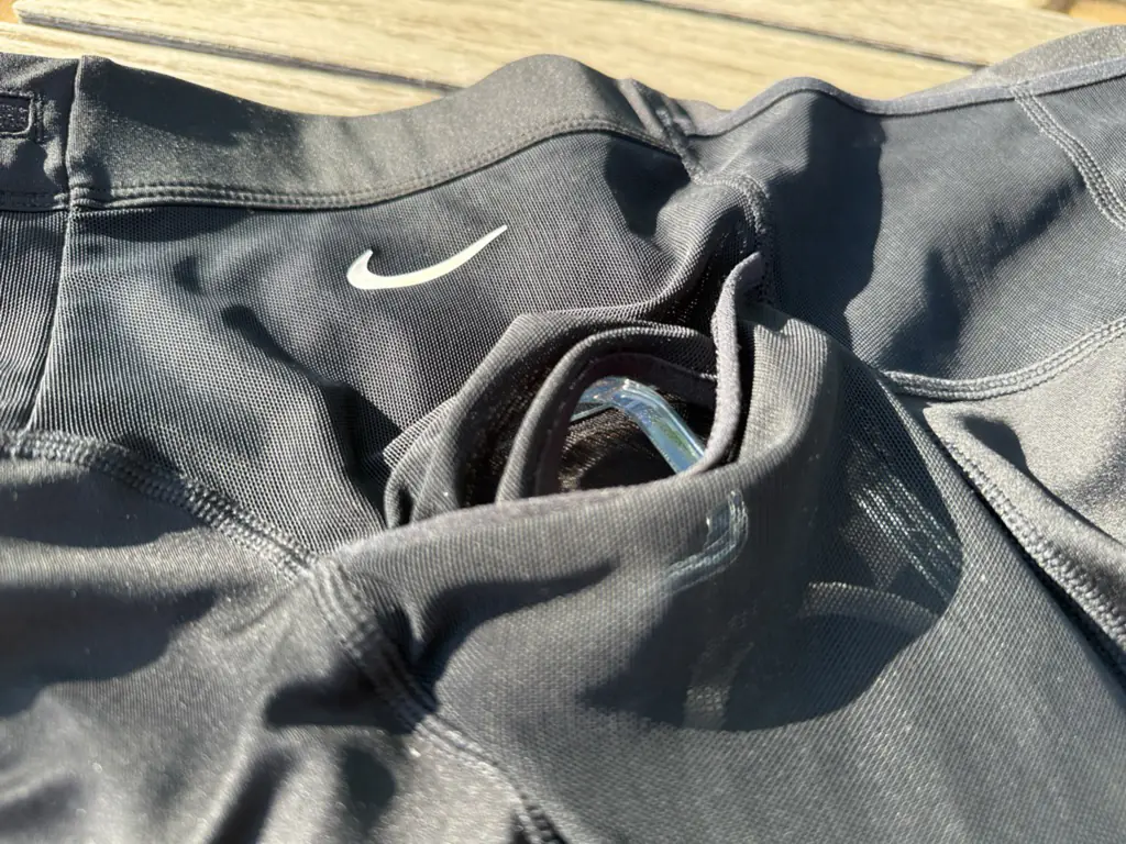 A close up view of the side pocket showing the unique top/bottom split opening, with the top mesh extending to the waistband