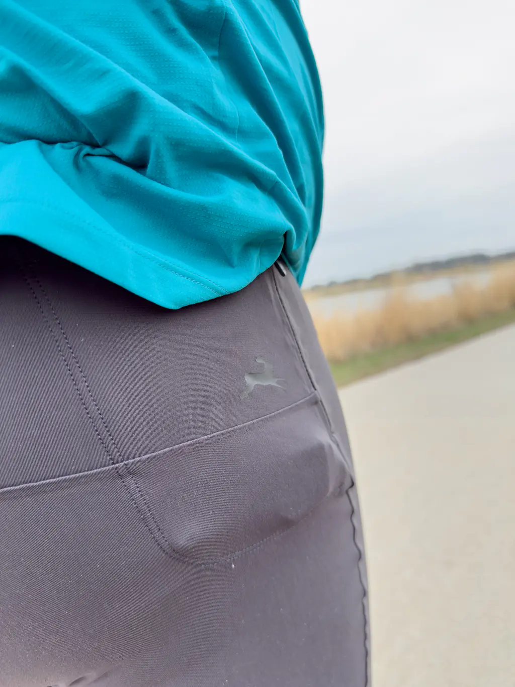 A closeup of a runner wearing the half tights with a smaller, more suitable item (a key) in the zippered pocket