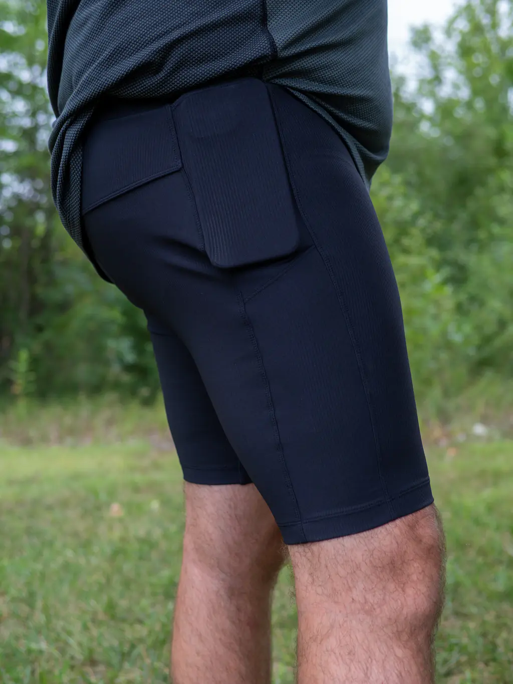 A bigger runner wearing the half tights with an iPhone 12 Pro Max fitting tightly in the side pocket.