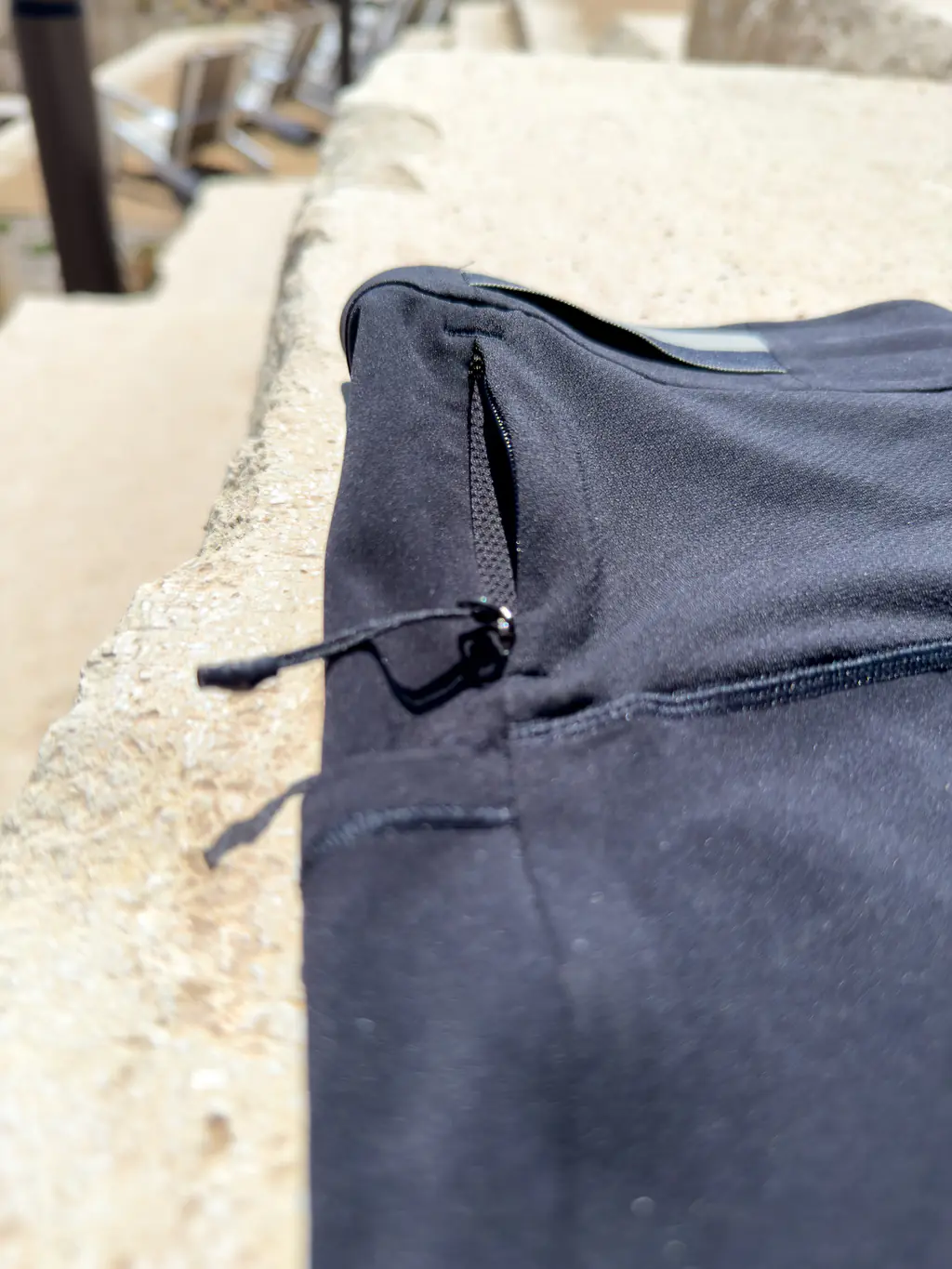 A rear side of the half tights, showing the small zippered pocket and one of the shirt hangers